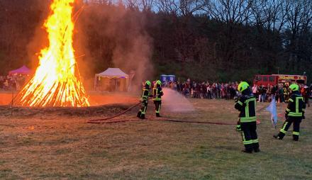 Feuer mit Feuerwehrmännern im Vordergrund