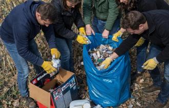 Personen sammeln Müll im blauem Sack