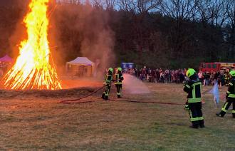 Feuer mit Feuerwehrmännern im Vordergrund