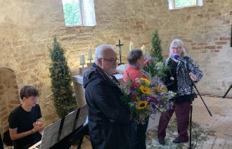 Pfarrerin Anke Spinola dankt den Verantwortlichen mit Blumensträußen