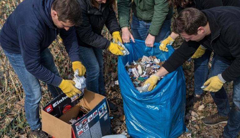 Personen sammeln Müll im blauem Sack