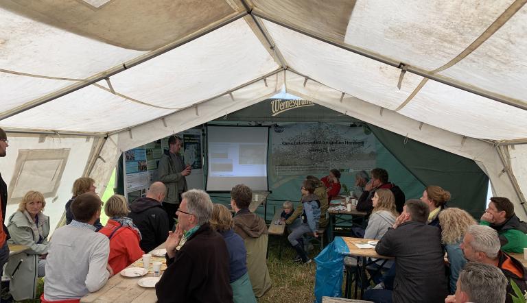 Streuobstwiesenfest 2025 im großen Festzelt des LPV Streuobstwiesenfest 2025 im großen Festzelt des LPV - Menschen schauen den Naturkundevrotrag