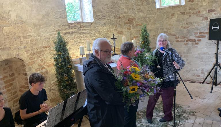 Pfarrerin Anke Spinola dankt den Verantwortlichen mit Blumensträußen